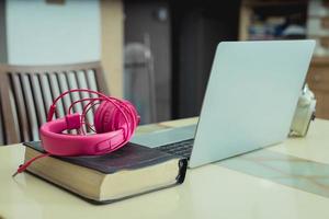 Laptop auf einem Tisch mit rosa Kopfhörern