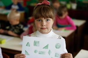 ein Mädchen von Kindergarten mit ein Muster von geometrisch Formen. foto