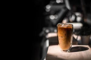 Nahaufnahme Glas Eiskaffee mit Milch auf dem Tisch foto