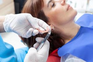 kieferorthopädisch Spezialist Zahnarzt einstellen ein Halter zum ein weiblich geduldig foto