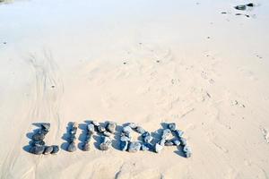 Briefe auf trocken Sand in der Nähe von das Wasser foto