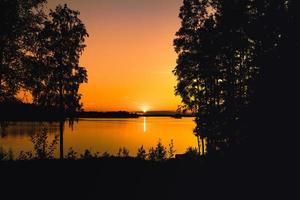 schöner orange Sonnenuntergang über einem See in Schweden foto