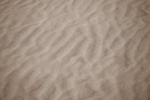 Beige Hintergrund mit Sand im das gestalten von Sand Wellen foto