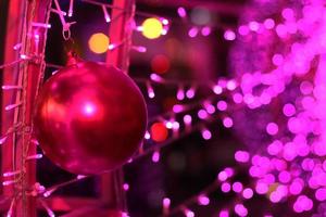 rot Ball im Glanz Ultra violett funkelnd und lila funkeln Bokeh von metallisch Kreis. mehrfarbig Weihnachten und Neu Jahr glühend Licht abstrakt zum Weihnachten und Urlaub Konzept. foto