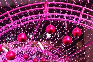 rot Ball im Glanz Ultra violett funkelnd und lila funkeln Bokeh von metallisch Kreis. mehrfarbig Weihnachten und Neu Jahr glühend Licht abstrakt zum Weihnachten und Urlaub Konzept. foto