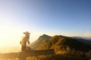 Weiß Schaf Puppe auf hölzern Zaun im schön natürlich von Sonnenaufgang leuchtenden auf das Senke Berg foto