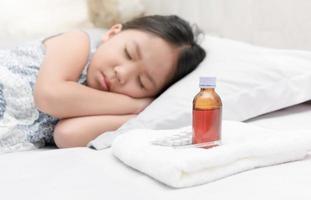 krank Mädchen Lügen im Bett und Medizin Sirup foto