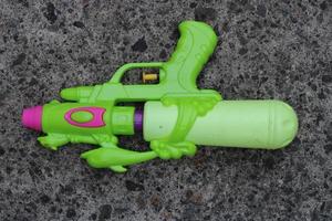 Foto von das Grün Spielzeug Gewehr auf das Boden