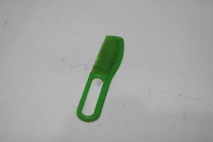 Foto von ein Grün Haar Kamm gemacht von Plastik mit ein Weiß Hintergrund
