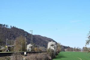 Eisenbahn mit Weiß Blühen Bäume um foto