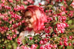 jung Mädchen mit Rosa Haar im Apfel Obstgarten. foto