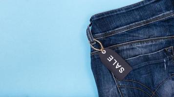 Jeans mit Verkaufsetikett auf blauem Hintergrund