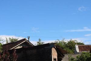 Foto von das Blau Himmel über das Dach Fliesen von das Haus