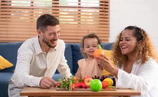 Eltern und Kinder entspannen im das Leben Zimmer von das Haus. Uhr Baby glücklich abspielen mit seine Liebling Spielzeug. foto