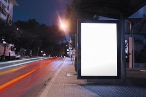 leere Plakat-Bushaltestelle Nacht mit Lichtern vorbeifahrende Autos