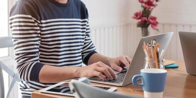 Person in einem Pullover mit einem Laptop foto