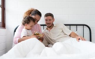 wenig Mädchen Vater lesen Geschichten zu Kinder Vor gehen zu Bett zu entspannen und Schlaf solide bis um das Morgen. foto