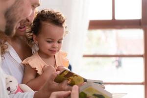 Eltern und Kinder entspannen im das Leben Zimmer von das Haus. Uhr Baby glücklich abspielen mit seine Liebling Spielzeug. foto