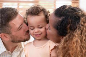 Eltern und Kinder entspannen im das Leben Zimmer von das Haus. Uhr Baby glücklich abspielen mit seine Liebling Spielzeug. foto