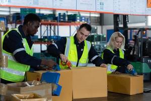 Gruppe von Arbeiter im Auto Teile Warenhaus Verpackung klein Teile im Kisten nach inspizieren das Auto Teile Das sind bereit zu Sein geschickt zu das Auto Versammlung Pflanze. foto