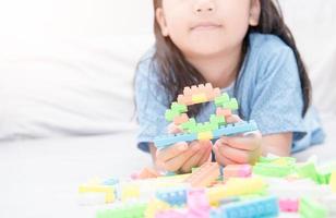 Mädchen abspielen Block Ziegel auf Bett, Bildung foto