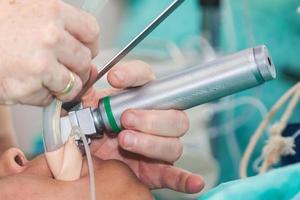 Anästhesist durchführen ein endotracheal Intubation zu ein weiblich geduldig beim das Anfang von ein Chirurgie foto