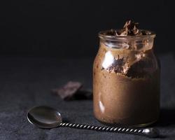 Nahaufnahme der köstlichen Schokoladenmousse in einem Glas mit silbernem Löffel foto