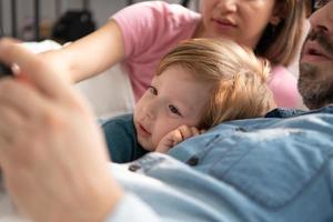 wenig Jungs Vater lesen Geschichten zu Kinder Vor gehen zu Bett zu entspannen und Schlaf solide bis um das Morgen. foto