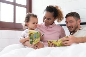 wenig Mädchen Vater lesen Geschichten zu Kinder Vor gehen zu Bett zu entspannen und Schlaf solide bis um das Morgen. foto