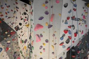 künstlich Klettern Mauer mit bunt Griff Felsen. foto