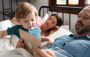 wenig Jungs Vater lesen Geschichten zu Kinder Vor gehen zu Bett zu entspannen und Schlaf solide bis um das Morgen. foto