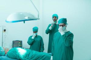 Porträt von Professor von Medizin im Kardiologie und ein Mannschaft von Ärzte im das Betriebs Zimmer unterziehen Herz Transplantation Chirurgie foto