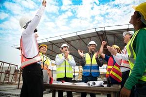 Konstruktion Ingenieure, Architekten, und Vorarbeiter bilden ein Gruppe. teilnehmen im ein Treffen zu planen Neu Konstruktion Projekte. Prost zu ausdrücken Glück Das das Veranstaltung war erfolgreich vollendet. foto