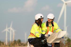 Mann und weiblich Ingenieur stationiert beim das natürlich Energie Wind Turbine Seite? ˅. mit Täglich Prüfung Aufgaben von Haupt Wind Turbine Operationen Das verwandeln Wind Energie in elektrisch Elektrizität foto