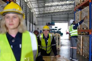 Arbeiter im Auto Teile Warenhaus verwenden ein Handwagen zu Arbeit zu bringen das Box von Auto Teile in das Lager Regal von das Warenhaus warten zum Lieferung zu das Auto Versammlung Linie foto