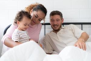 wenig Mädchen Vater lesen Geschichten zu Kinder Vor gehen zu Bett zu entspannen und Schlaf solide bis um das Morgen. foto