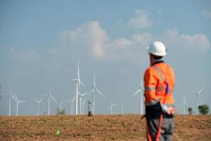 Ingenieur beim natürlich Energie Wind Turbine Seite? ˅ mit ein Mission zu nehmen Pflege von groß Wind Turbinen verwenden ein Walkie Talkie zu kommunizieren mit ein Kollege Arbeiten auf oben von das Wind Turbine. foto