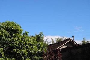 Foto von das Blau Himmel über das Dach Fliesen von das Haus