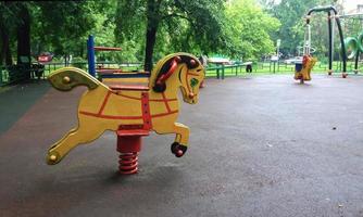 leeren Kinder Spielplatz im Wohn Bereich, schaukeln Pferd im Sommer- Hinterhof foto