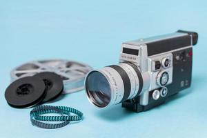 Filmrollen und Filmstreifen mit Vintage-Camcorder auf blauem Hintergrund foto