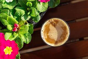 Tasse von Kaffee draussen Blume Primel mehrfarbig Kopieren Raum Essen Hintergrund rustikal oben Aussicht foto