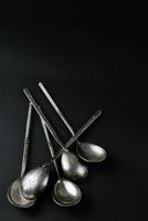 fünf Jahrgang Silber Teelöffel auf schwarz Hintergrund foto