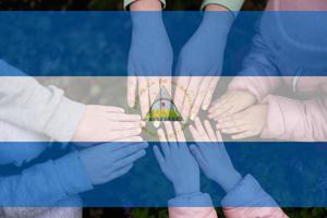 Hände von Kinder auf Hintergrund von Nicaragua Flagge. nicaraguanisch Patriotismus und Einheit Konzept. foto
