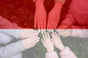 Hände von Kinder auf Hintergrund von Indonesien Flagge. indonesisch Patriotismus und Einheit Konzept. foto