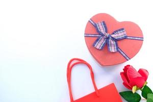 Draufsicht einer herzförmigen Geschenkbox und Rose auf einem weißen Hintergrund foto