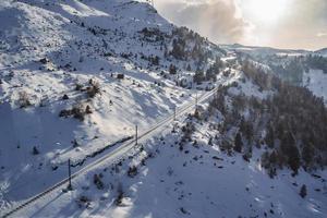 Eisenbahn Spur Vorbeigehen durch schön Schnee bedeckt Berge foto