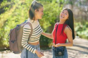 Erfreut asiatisch Frauen mit Rucksack im sonnig Wald foto