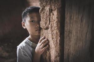 Porträt von ein Arm wenig Thailand Junge hat verloren im tief Gedanken, Armut, Arm Kinder, Gewalt gegen Kinder. foto