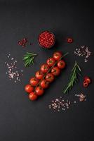 köstlich frisch Kirsche Tomaten auf ein Zweig auf ein dunkel Beton Hintergrund foto