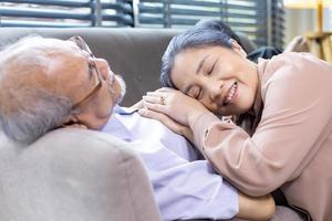 Der Senior leidet an einem Herzinfarkt, während seine Frau seine Hand zur Unterstützung und Ermutigung für Mitgefühl und Beileid hält foto